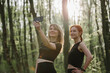 © dsheremeta - Two women taking a selfie in the woods after exercising
