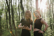 © dsheremeta - Women exercising in a sunlit forest setting
