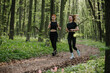 © dsheremeta - Women jogging through serene forest path