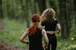 © dsheremeta - Women running through lush forest trail