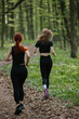 © dsheremeta - Women jogging through lush forest trail
