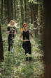 © dsheremeta - Women running through a forest trail