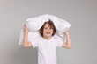 © New Africa - Cute little boy in pajamas with pillow on grey background