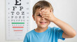 © MUHAMMAD - A Young Boy Covering One Eye During a Vision Test at an Optometrist's Office