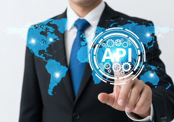 businessman touching a glowing blue api icon with a world map background, representing global techno