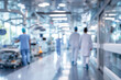 © pilipphoto - Blurred background of a hospital interior with medical equipment and busy hospital staff in motion