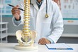 © Ultimate Image Flow - Doctor explains spinal anatomy using a detailed human spine model and medical chart