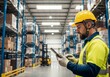 © tebu - Warehouse worker in safety gear uses tablet amidst shelved boxes and a forklift