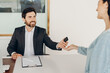© Maria Vitkovska - Car salesman giving car key to client in dealership office
