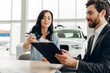 © Maria Vitkovska - Salesman showing contract to customer buying new car in dealership