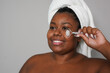 © Sabrina - Happy african curvy woman doing skin care treatment - Spa, wellness and beauty facial care