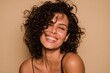 © Octopus - A vibrant woman with curly hair flashes a warm smile against a neutral background radiating happiness and positivity