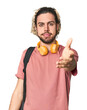 © Asier - Young student with backpack and headphones stretching hand at camera in greeting gesture.
