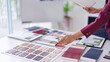 © STBSTD - Adult Asian hand chooses material samples interior design office architect selects color palettes residential commercial projects workspace creative professional