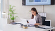 © Pichsakul - Asian adult woman architect or real estate agent works on property plans in a modern office space discussing home investment and sales strategy