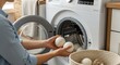 © Nan_Stock - Woman using wool dryer balls for eco-friendly laundry in bright, modern home for clean clothes