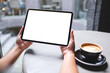 © Farknot Architect - Mockup image of a woman holding digital tablet with blank white desktop screen in cafe