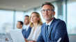 © peter maya - A focused professional man listens intently during a business meeting, seated with colleagues in a modern office environment.
