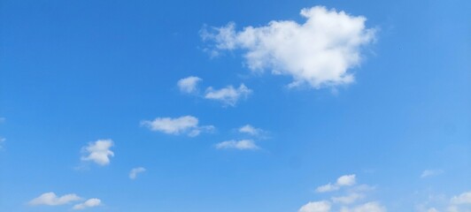 Wall Mural - Bright white cumulus clouds floating in a clear blue summer sky. Blue sky with clouds. Soft white clouds float in the clear blue sky. Clear blue sky, bright spring, wallpaper landscape.