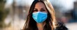 © Chayanan - Portrait of young woman in blue virus face mask, wide banner with wearing disposable mouth