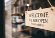 © Jahid - Photo of a wooden sign hangs on the door of a shop, saying welcome we are open please come in, inviting customers inside