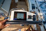 View from above of a man steering a sailing yacht using navigation display and control panel near Croatia. Precision, control and modern sailing lifestyle at sea.