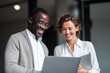 © Mike - Diverse Professionals Sharing Joyful Moment at Laptop in Modern Office - Caucasian and African American Teammates Collaborating Near Window