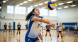 © Kaluya Stock - Young woman playing volleyball indoors, bumping the ball with her forearms