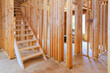 © ungvar - Wooden framing in residential construction site reveals staircase an open layout ready for further development.