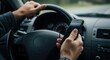 © moonart - Hands grip steering wheel while holding smartphone, demonstrating distracted driving in a car traveling on a clear, expansive road under daylight
