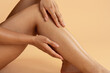 © Anastasiya - Closeup of woman sitting and gently touching soft smooth skin on her shin. Soft, elegant beauty and skincare concept perfect for leg care, hair depilation, self love, or feminine body routine visuals
