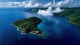 Drone shot of a large forested island surrounded by deep blue ocean, rugged coastline, clouds casting soft shadows, isolated paradise, perfect for unique travel stock photo