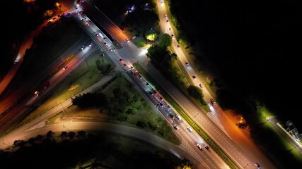 Wall Mural - a street with cars and a crosswalk. the street is lit up at night. there are many cars on the street