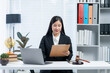 © Kritdanai - Legal Professional at Work: A focused legal professional diligently reviewing documents in a well-organized office environment, laptop and gavel at her side, symbolizing her commitment to justice.