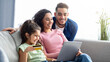 © Prostock-studio - Happy Arabic Family Using Digital Tablet And Credit Card For Online Shopping, Relaxing On Couch At Home, Young Parents And Their Little Daughter Making Purchases From Internet Together, Free Space