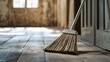© embun - A broom resting on a dusty wooden floor inside a building