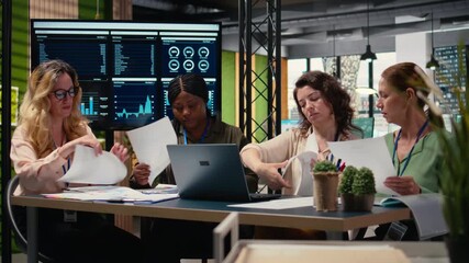 Poster - Women leaders group collaborate over performance indicators to create a new financial strategy in a multinational company office. Associates aligning resources with project objectives. Camera A.