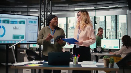 Poster - Diverse women professionals focus on report writing and analytics in office, showcasing empowerment through goals and determination for success in a competitive work environment. Camera A.