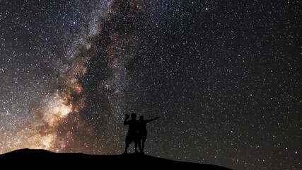 Wall Mural - The lovers stands  on the hill on the  Milky Way galaxy and  mountains background. Night tight landscape starry sky.