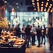 © Selvi - A blurred scene captures a sophisticated social gathering with people mingling near a buffet table under ambient lighting, creating a warm and inviting atmosphere.