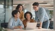 © Big - Group of four colleagues collaborating on a project using a laptop in a modern office setting.