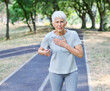 © Lumos sp - Active mature middle aged woman jogging running with a chest cardiac pain in the park