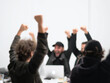 © don - A DSLR photograph of a team celebrating a successful idea during a meeting. The shot is cinematic and full of energy. The white background is bright. The angle is celebratory, and the details are rich