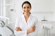© Irene Kulinchyk - Female dentist smiling, holding dental tools in modern clinic, looking confident in white lab coat.