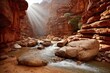 © Ippang - Sunbeams illuminate a narrow canyon, flowing river, and large rocks