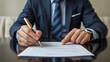 © nassim - Businessman signs a document, formal agreement.