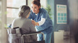 © sebra - Senior woman in a wheelchair being cared for a nurse