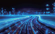 © hakule - The image is a blurred view of a city street with a car in the middle. The street is filled with bright lights and the car is moving quickly, creating a sense of motion and energy