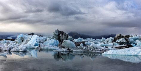 Wall Mural - panorama of beautiful blue icebergs under a stormy sky in the jokulsarlon glacial lagoon, southern i