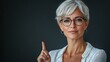 © mikail - Confident mature woman pointing upwards.